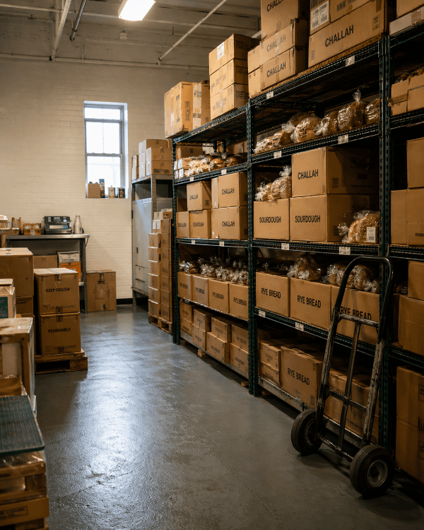 Route vendor's distribution warehouse stacked with boxed baked goods